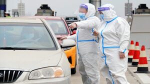 Контролеры проверяют результаты анализов на нуклеиновые кислоты и "коды здоровья" на платной автомагистрали в Яньтае, провинция Шаньдун